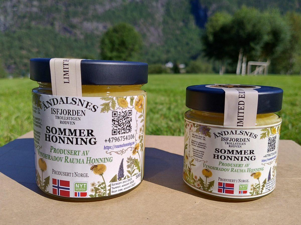 Glass jar of Rauma Honning summer honey (Sommerhonning) from Åndalsnes, Norway, with mountains in the background